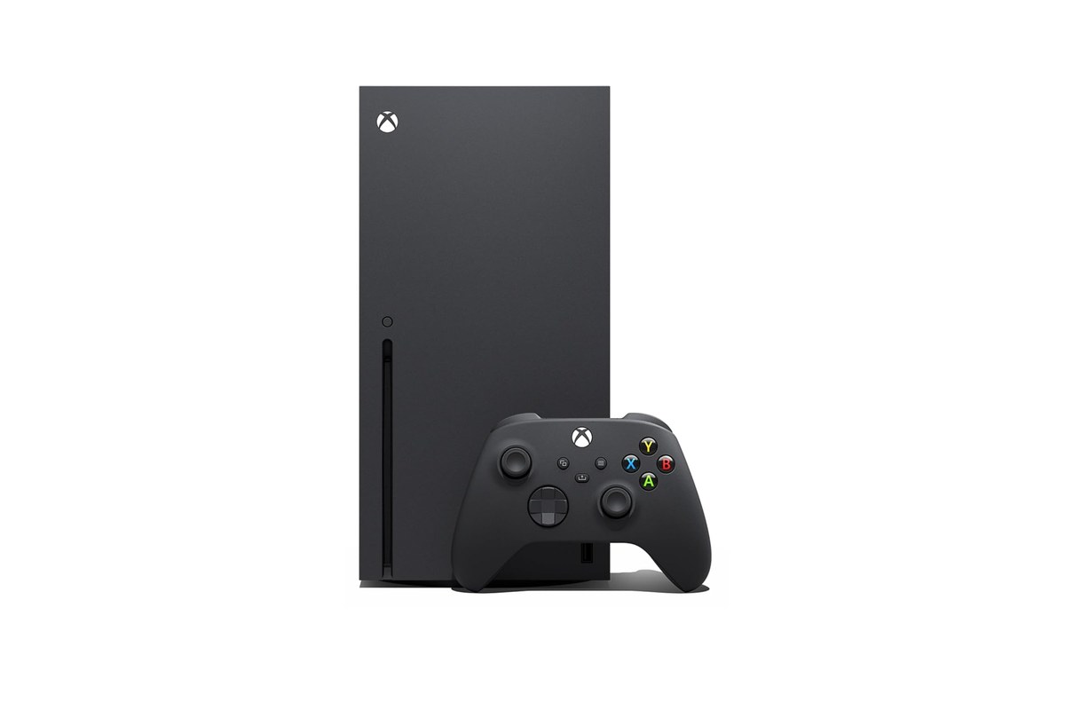 The Xbox Series X console in Carbon Black standing upright next to its wireless controller, from the Amazon listing